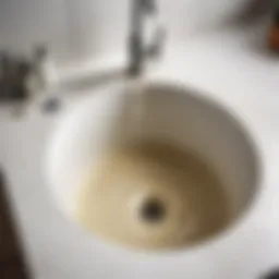 Clogged sink drain with water buildup.