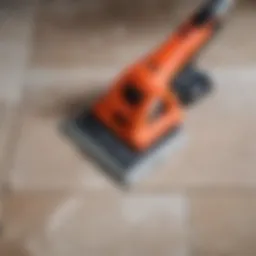 A close-up view of a tile removal tool on the floor.